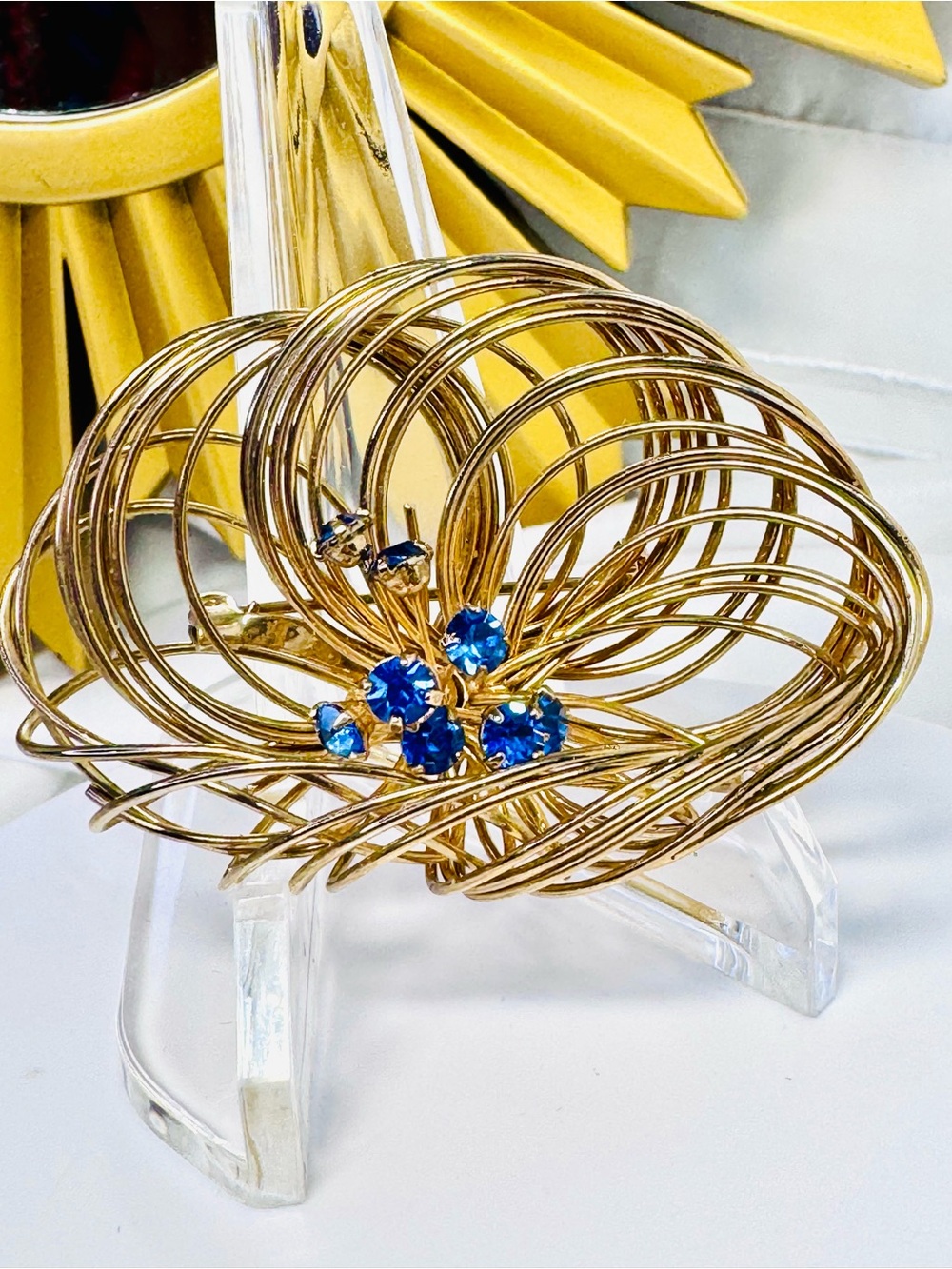 vintage gold-tone wire swirl brooch featuring a cluster of vibrant blue crystals
